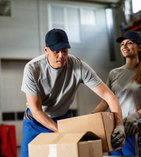 warehouse-worker-assisting-female-colleague-with-packages-industrial-storage-compartment-1536x1024